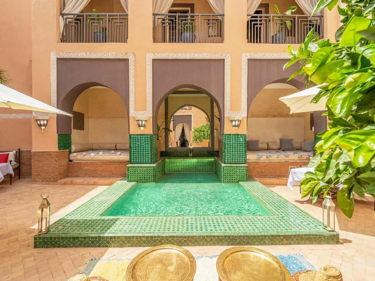 La cour du riad : arcs outrepassés autour d'un bassin de zellige vert
